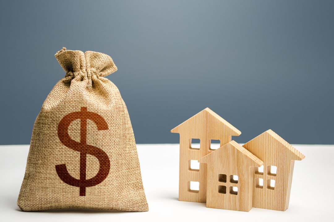 Dollar,Money,Bag,And,Figurines,Of,Residential,Buildings.,Mortgage,Loan.